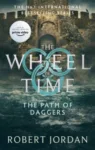 The Path of Daggers paperback, Orbit's September 2021 edition. The cover depicts the portcullis gate of a city wall, and the choppy water that rolls against it.