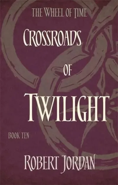 Crossroads of Twilight paperback, Orbit's 2014 edition. The cover has the snake-wheel symbol on a damson background.