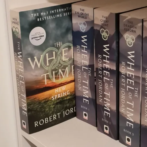 The Wheel of Time books on a shelf with New Spring pulled forwards. Signifying its position if you read New Spring before starting The Wheel of Time series.