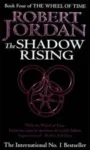 The Shadow Rising paperback. Time Warner Books UK's 1993 edition. The cover has a purple snake-wheel symbol on a black background.