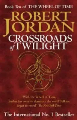 Crossroads of Twilight paperback, January 2003 edition from Orbit. The cover has a gold snake-wheel symbol on a red-pattern background.