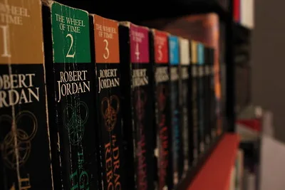 The complete Wheel of Time series of paperback books on a shelf.