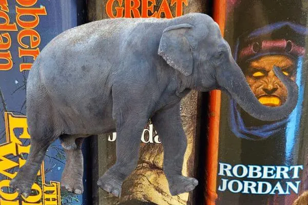 An elephant is set against a background of Wheel of Time books.