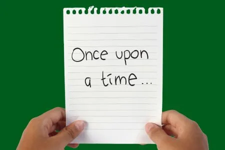 Hands holding up notepad paper with “Once upon a time…” written simply on the page.