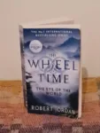 Orbit’s 2021 paperback edition of The Eye of the World is half open on a patchwork blanket.